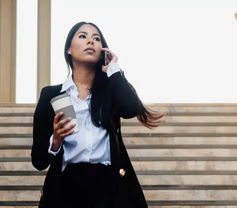 An Image of a Woman Holding a Coffee While Having Phone Conversation