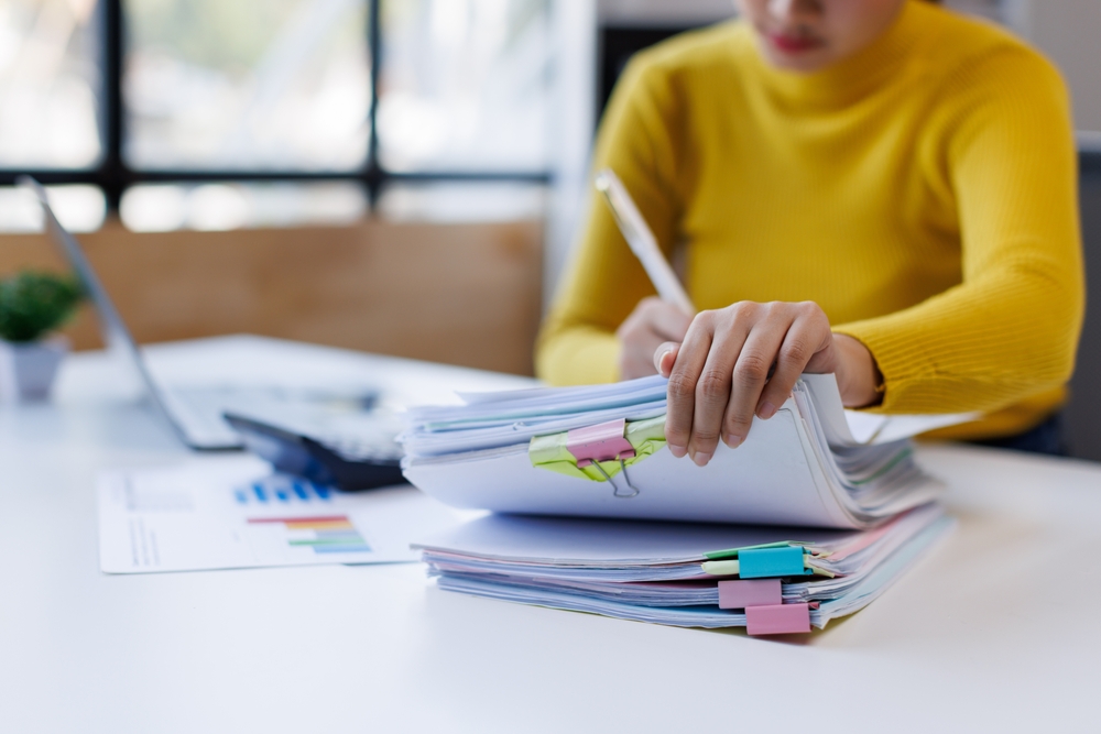 Business,asian,woman,hands,working,in,stacks,of,paper,files