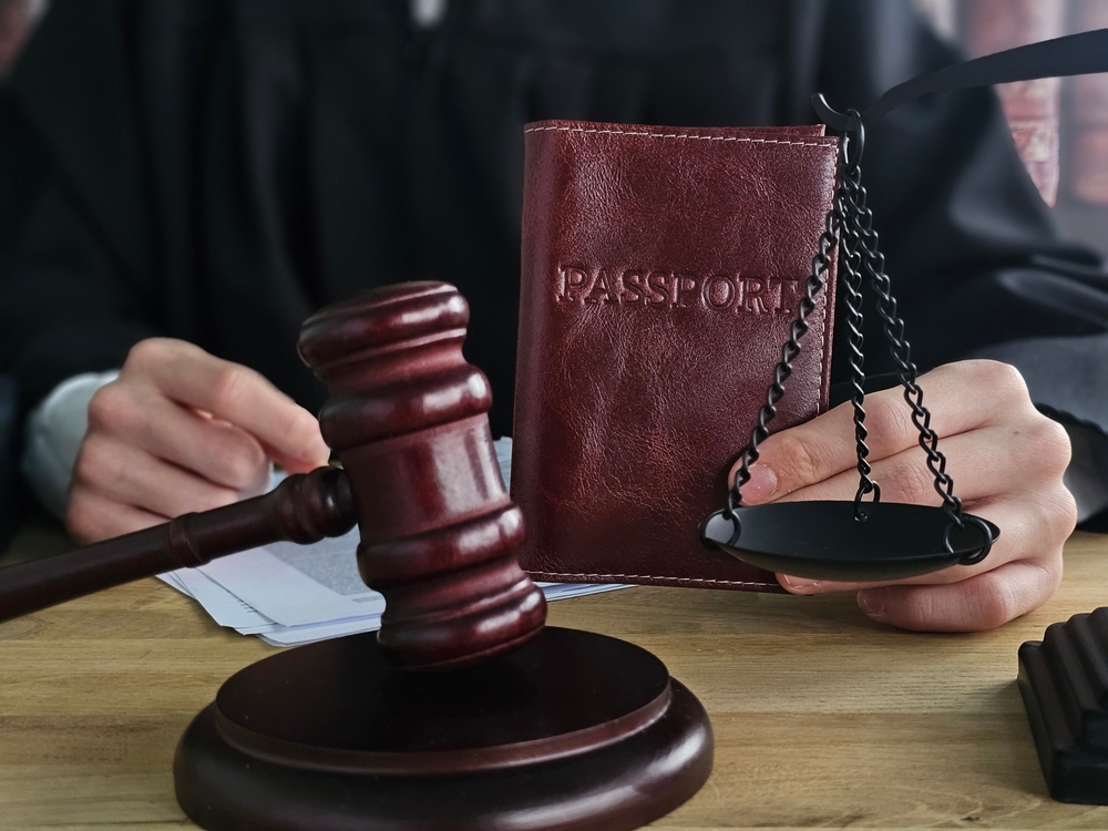 Judge,With,Illegal,Immigrant,Passport,In,Hand,Knocking,With,Gavel